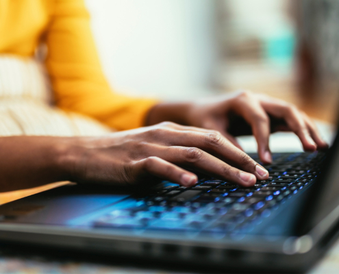 Close up hands typing using laptop computer