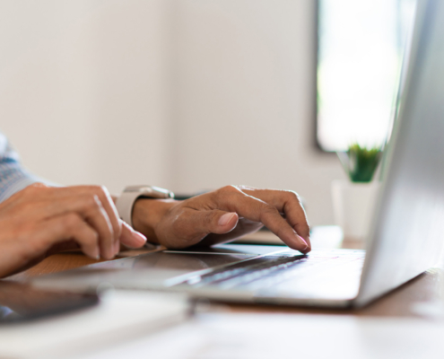 Side view of hands typing on a keyboard