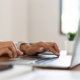 Side view of hands typing on a keyboard