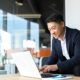 Side view of smiling man on laptop computer in office setting