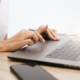 Side view, woman with manicured hands using laptop keyboard