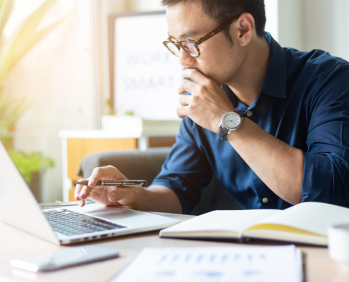 Side view, man in glasses looking at computer very focused