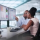 Two workers looking at data on computers