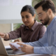 Two people at work using laptop