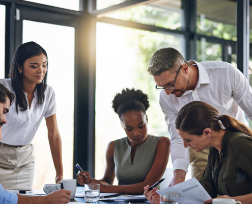 workers look at paperwork in conference room'